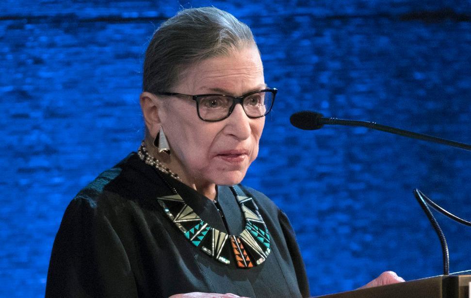 Ruth Bader Ginsburg standing behind a microphone. 