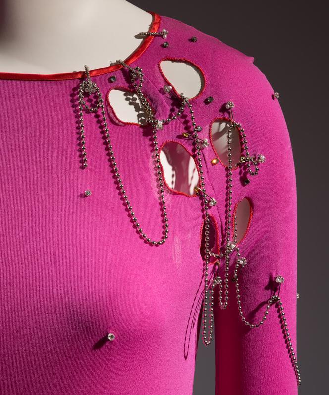 Antrekk designa av Zandra Rhodes  i rosa jersey med hol og store sikringsnåler pynta med perler. Foto.