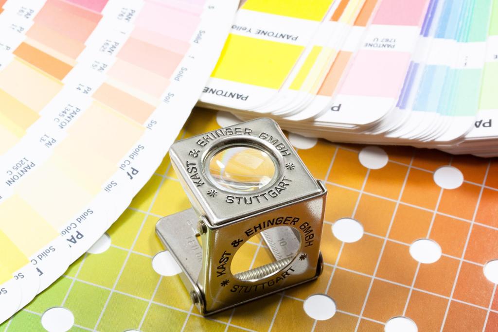 Grafisk forstørrelsesglass med Pantone fargekart- Foto.