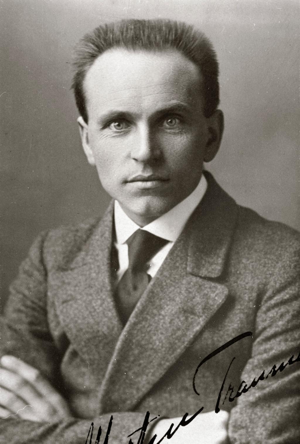 Portrett av mann i ulldress, med hvit skjorte og slips. Han har armene i kryss. Mannen er Martin Tranmæl. Foto. 