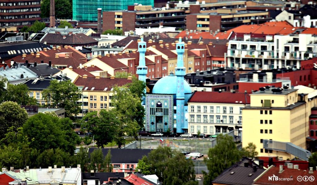 Flyfoto av bygårder og blokker. Midt i bildet står en moské. Foto.