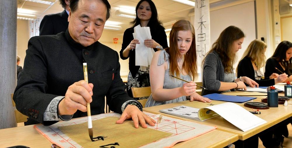 Kinesisk mann lærer studenter og skrive kinesiske tegn. Foto.