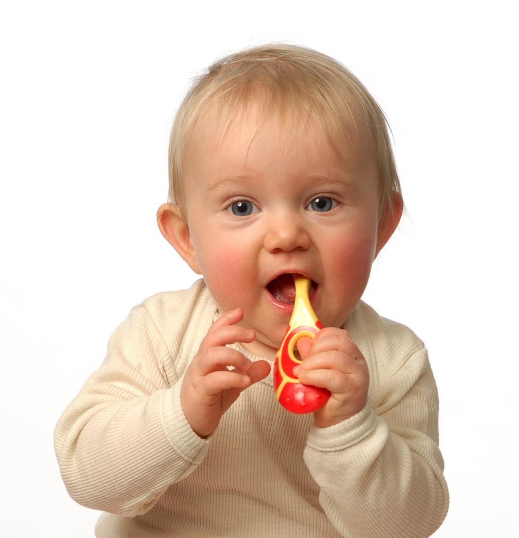 Eit lite barn som held ein tannbørste i munnen. Foto.
