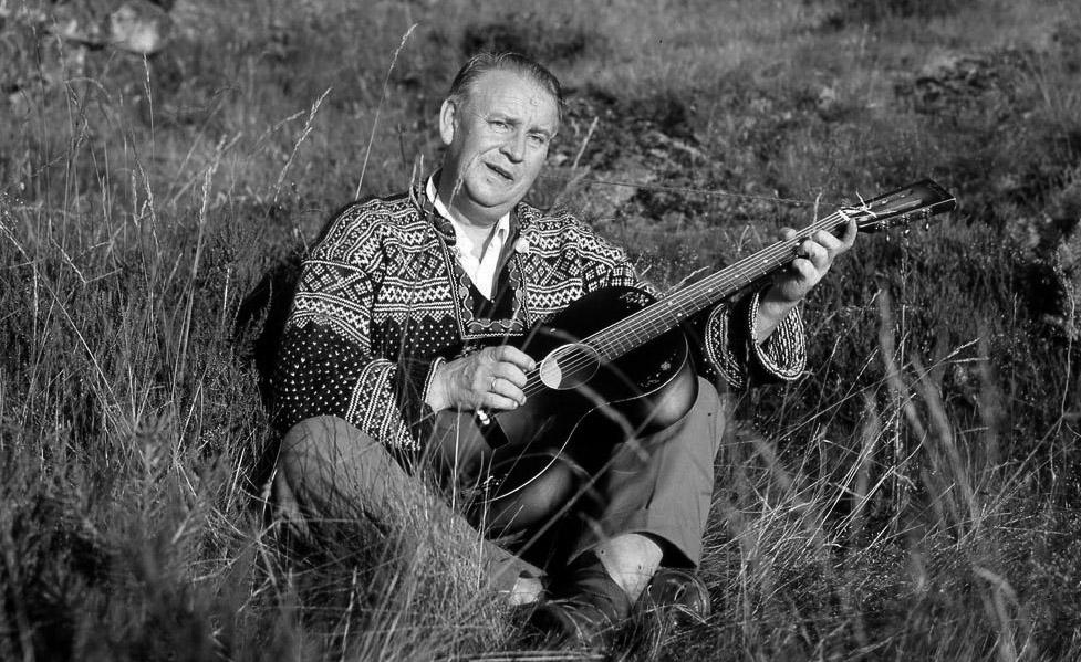 Alf Prøysen med gitar. Svart-hvitt-foto.