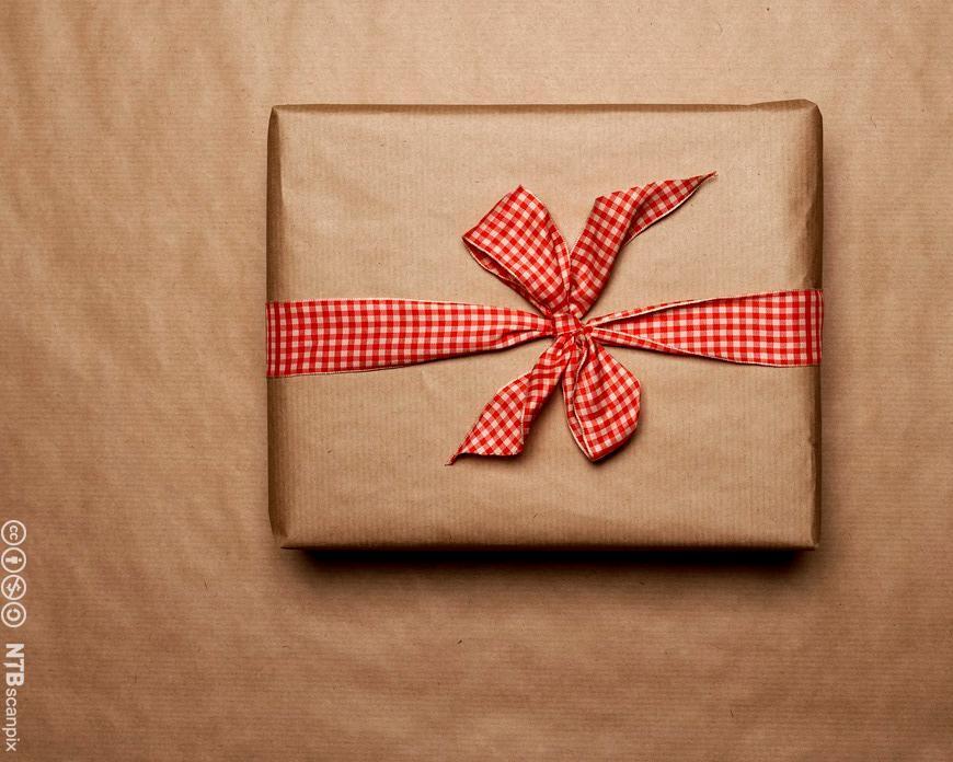 Photo: Gift wrapped in brown paper. It has a red and white bow. 