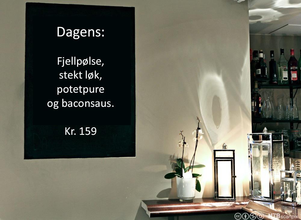 Foto av ei menytavle i ein restaurant, som annonserer dagens rett: Fjellpølse, steikt lauk, potetpure og baconsaus.