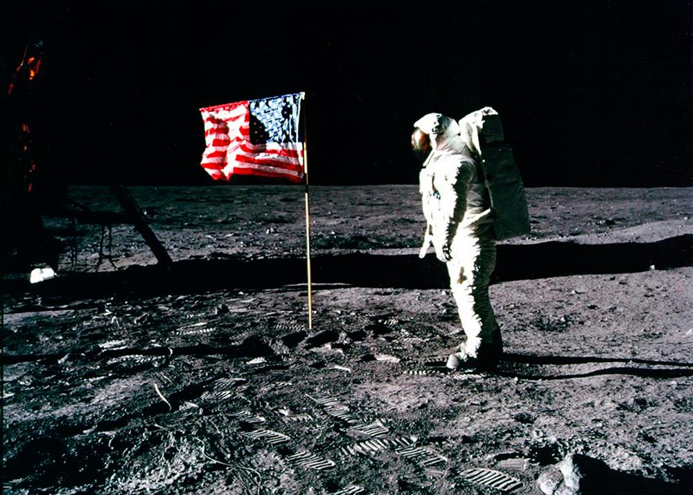 Buzz Aldrin på månen med et amerikansk flagg. Foto.