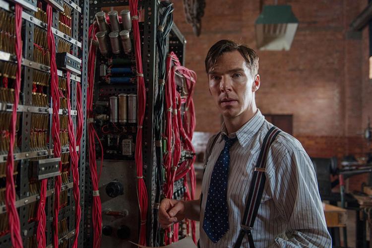 Alan Turing (spilt av Benedict Cumberbatch) står foran datamaskinen sin, som er flere meter stor og består av massevis av ledninger. Foto.