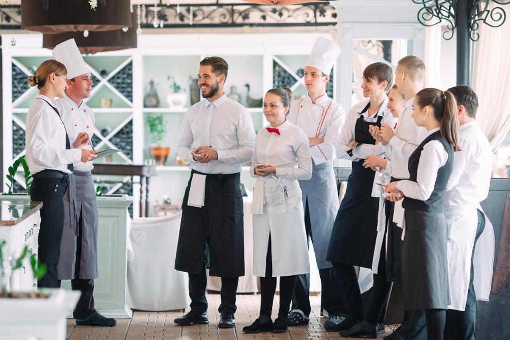 Kokker og servitører snakker sammen i en restaurant. Foto.