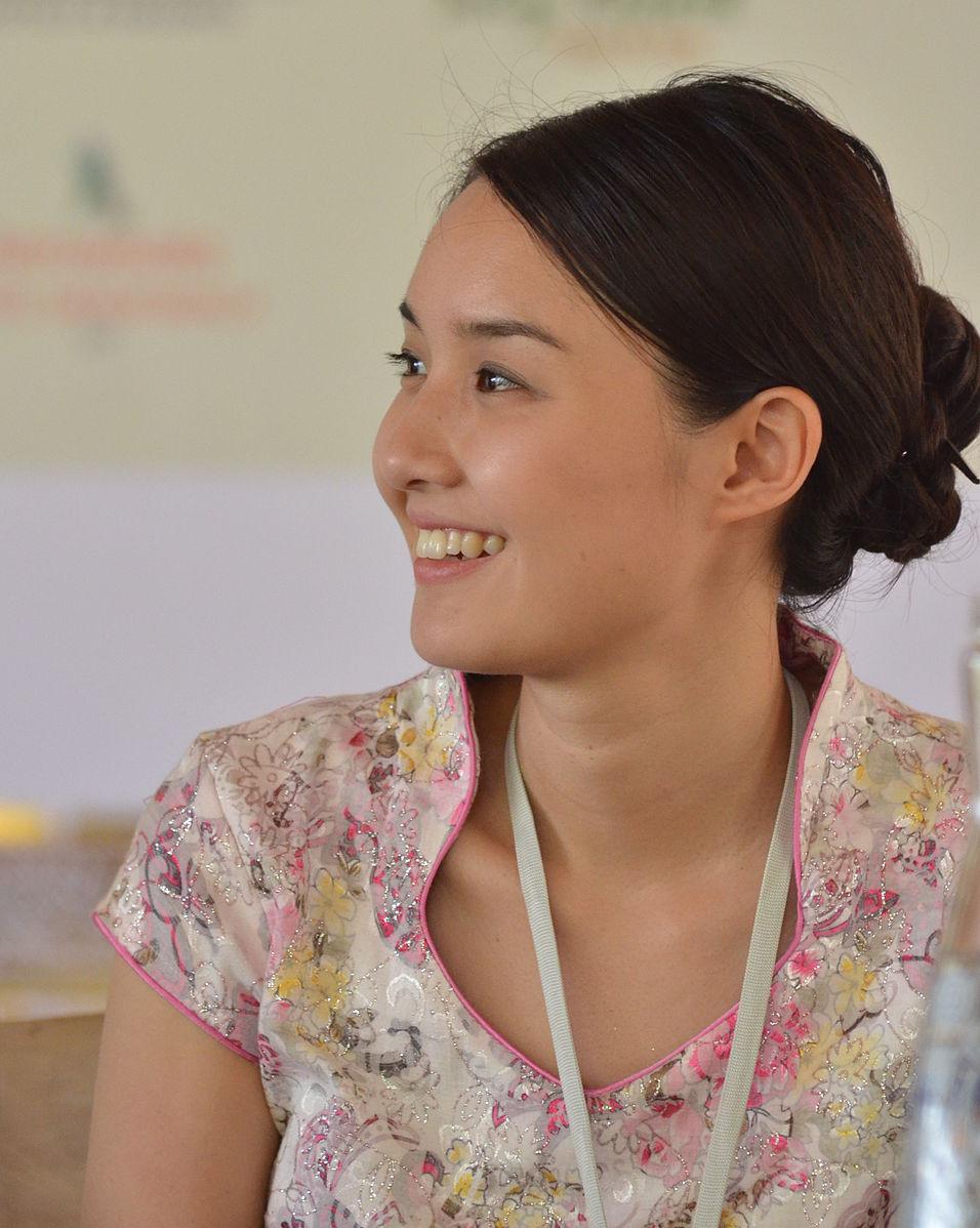 A photo showing the Australian author Alice Pung. She is a young, Asian-looking woman, who is dressed in a pink top. She is smiling, looking away from the camera.