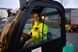 Bildet viser en kvinnelig truckfører i en motvektstruck