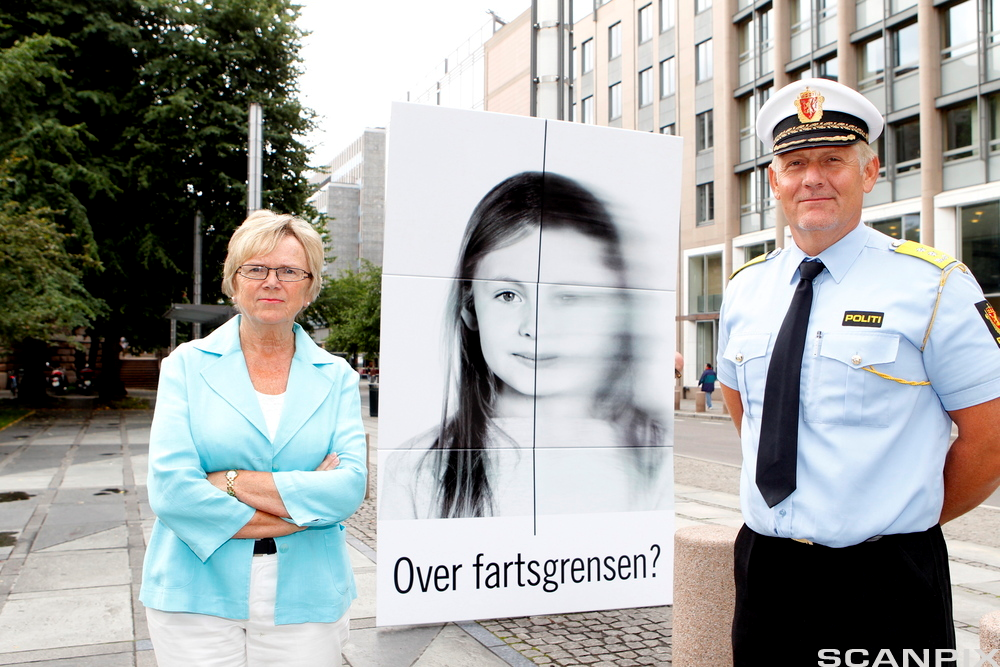 Daværende samferdselsminister Magnhild Meltveit Kleppa og sjef for Utrykningspolitiet Runar Karlsen flankerer et av Vegvesenets skilt som oppfordrer bilister til å følge fartsgrensen. Foto.