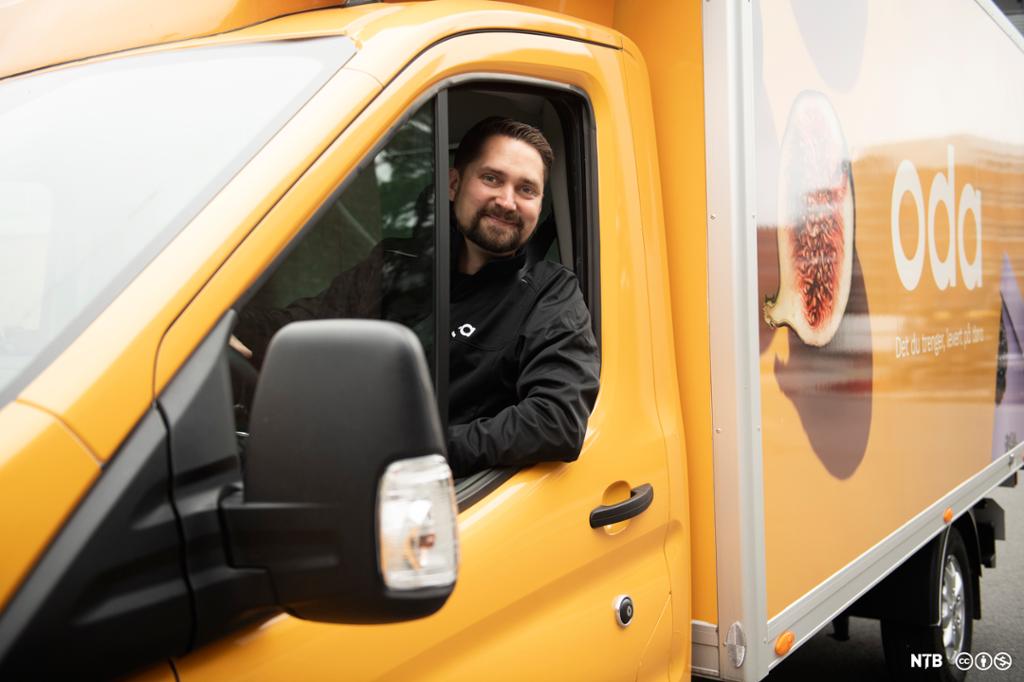 Fotografi som viser Karl Munthe-Kaas, administrerande direktør og medgründer i Oda, sitjande i ein av Oda sine gule lastebilar som dei bruker til å frakte daglegvarene dei sel på nett. 