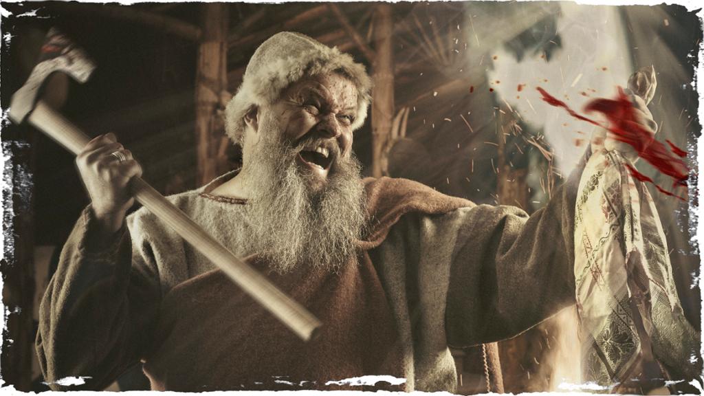 Vikingkriger med øks slåss innendørs. Blod spruter mot ham. Foto.