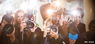 En rekke journalister rekker mikrofonen mot deg og fotograferer deg med store speilreflekskameraer med blits. Foto.