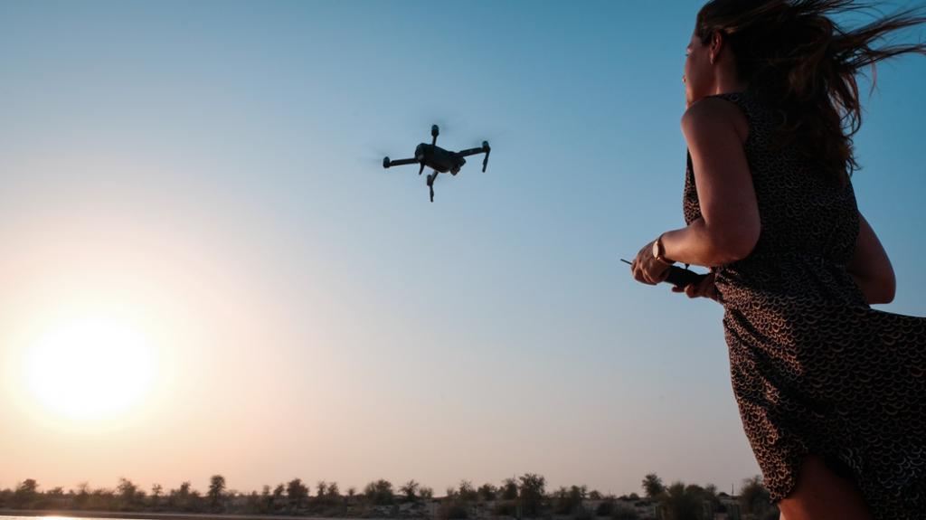 Kvinne flyr en drone. Bilde.