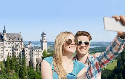 Bilde som viser to unge som tar en selfie foran slottet Neuschwanstein. Foto.