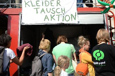 Mennesker strømmer til et marked der en kan bytte brukte klær med hverandre. Foto.