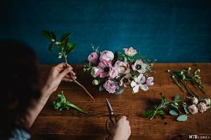 Hender som jobber med blomster. Foto.