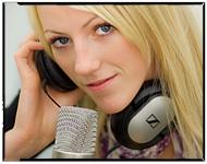 Foto av kvinne som lytter til øreklokker foran en mikrofon.