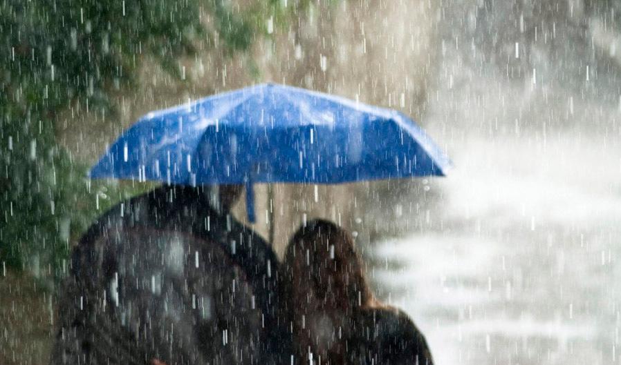 Et par går under en blå paraply i regnvær. Foto. 