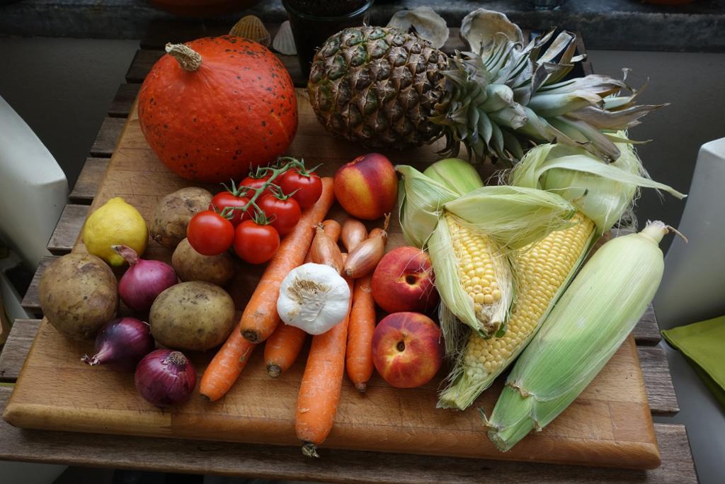 Frukt og grønnsaker presentert på ei skjærefjøl. Foto.