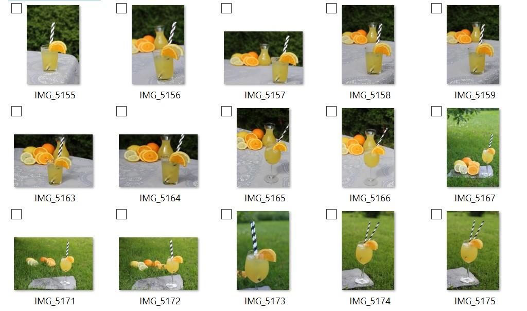 Du ser 15 ulike fotografier av et glass med gul limonade. Det er oppskåret frukt på kanten og ved siden av glasset. Fotografiene er tatt ute med grønt gress i bakgrunnen. Skjermbilde.