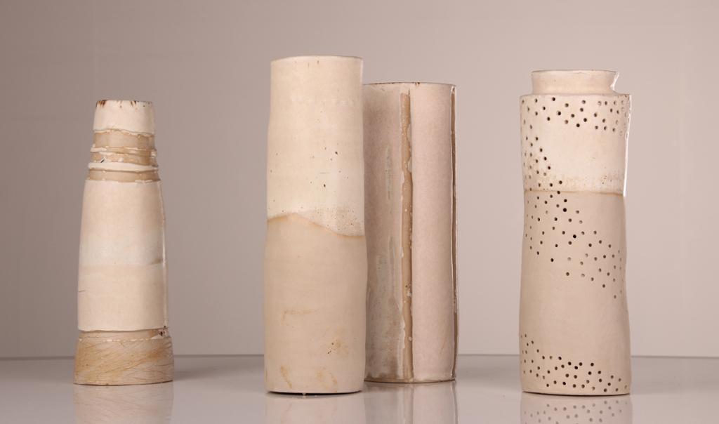 Fotografi av fire  vaser i hvit keramikk.