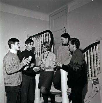 Fem ungdommer står i en trapp og diskuterer. Foto. 