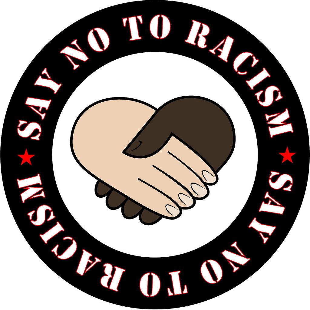 Ei mørk og ei lys hånd danner et hjerte inne i en ring, der ordene "say no to racism" står skrevet. Illustrasjon.