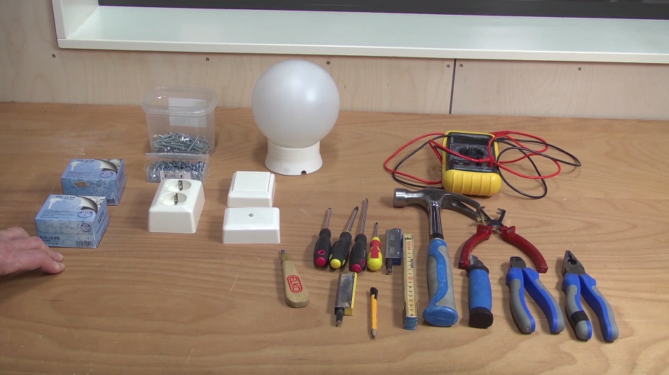 Utstyr og komponenter til åpen installasjon: brytere, knotakter, skruer, lampe, multimeter og ymse verktøy. Foto.