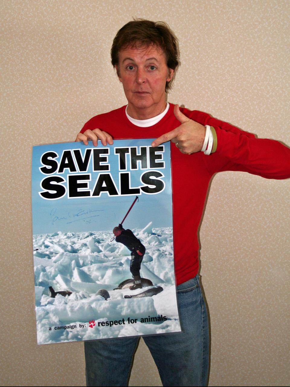 Paul McCartney holding the poster "save the seals". Photo.