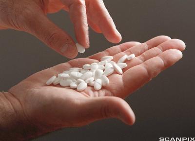 Flere hvite tabletter i ei hånd. Foto.