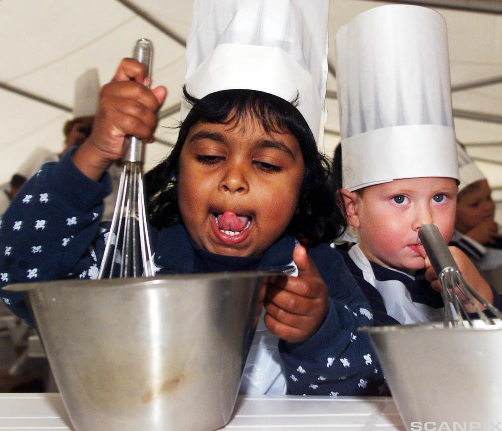To barn som lager mat. Foto. 