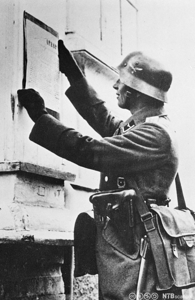 En tysk soldat slår opp kunngjøringen Falkenhorsts proklamasjon, i Trondheim 9. april 1940.