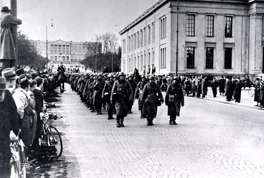 Tyske soldater marsjerer på Karl Johans gate ved Universitetet. Svart-hvitt foto. 