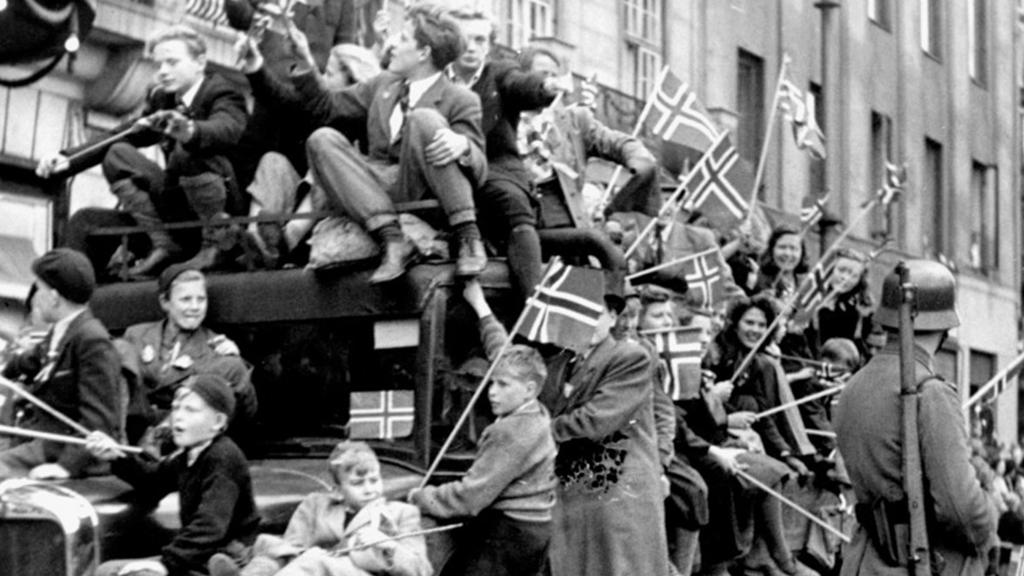 Lastebil full av jublende mennesker på Karl Johans gate, 8. mai 1945. Foto. 