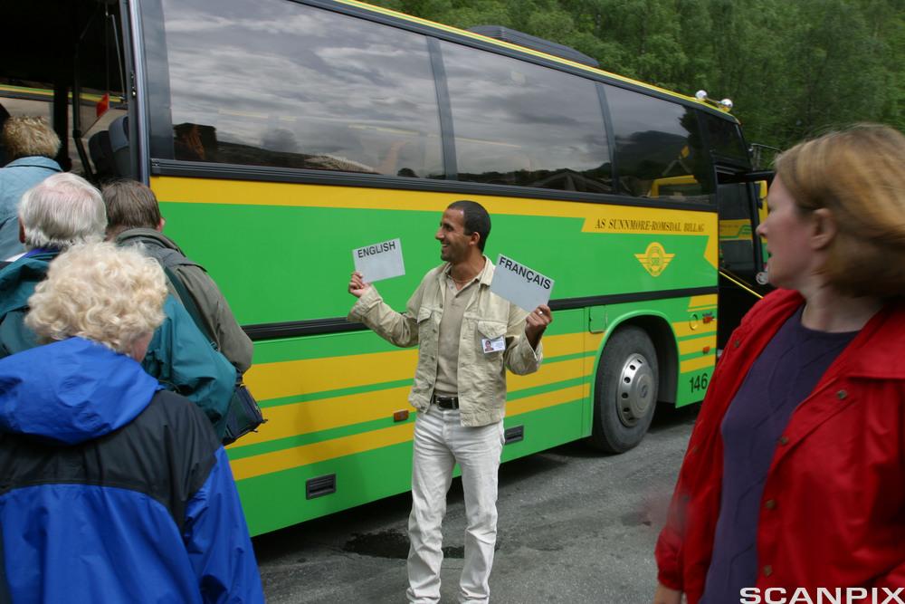 Guide framfor ein turistbuss på Geiranger. Foto.