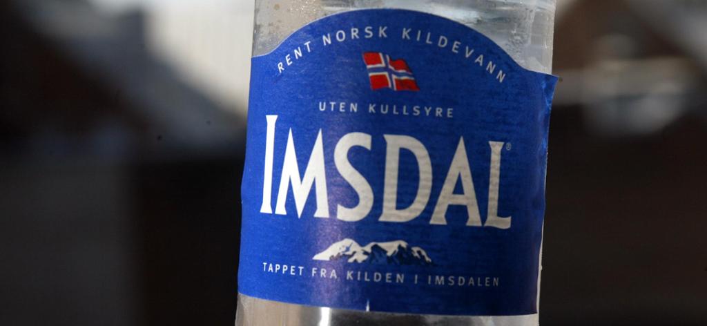 Nærbilde av en flaske Imsdal-vann. Foto.