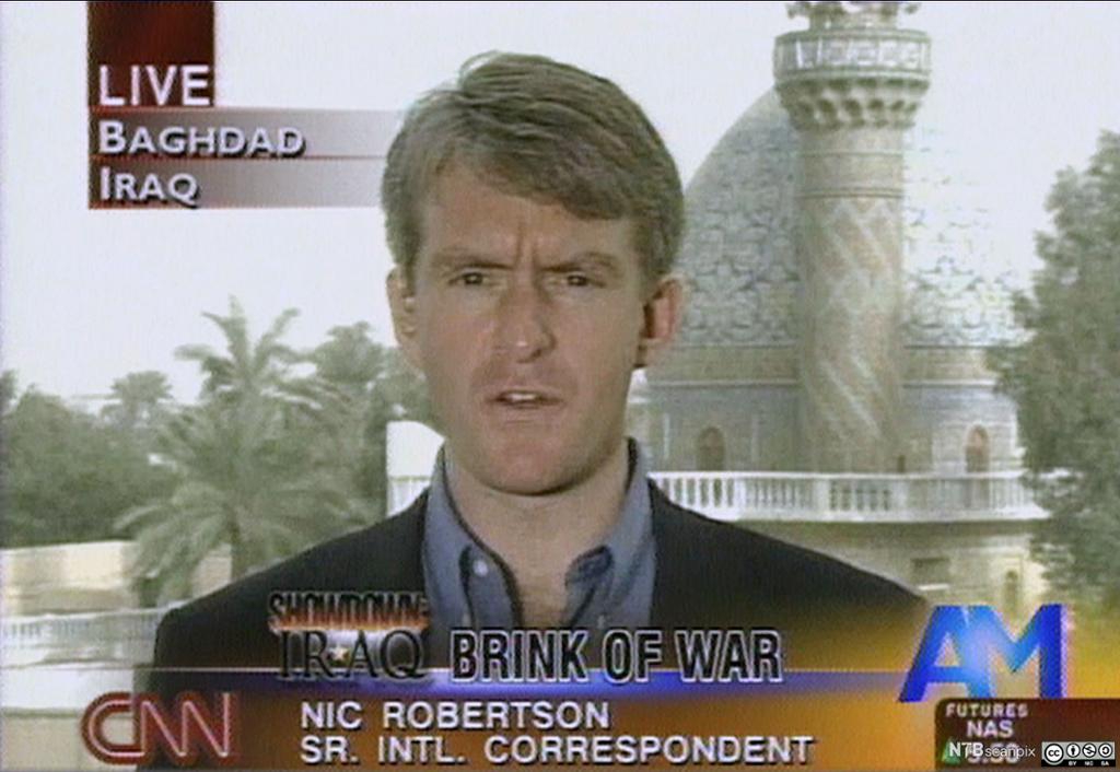 TV-bilete der CNN-reportar Nic Robertson rapporterer live frå Irak med ein moské og palmetre i bakgrunnen. Foto.