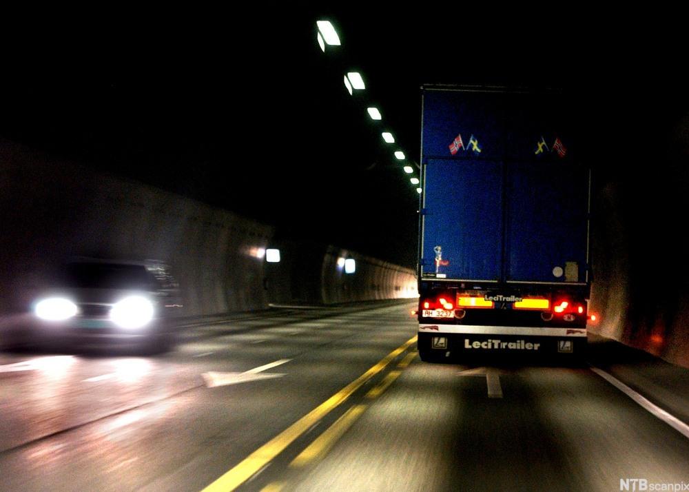 Bakenden av ein lastebil i ein mørk tunnel. Foto. 