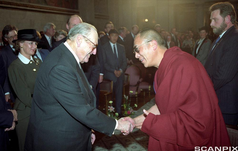 Dalai Lama helsar på kong Olav V under utdelinga av Nobels fredspris i Oslo i 1989. Foto.