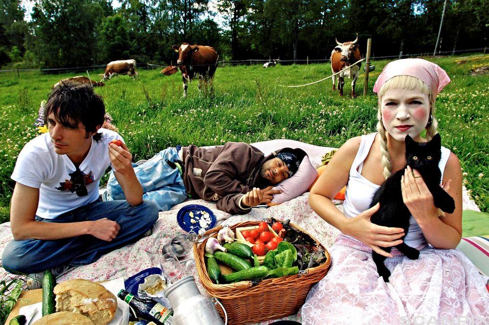 Artister serveres økologisk mat på Ramme gård. To ungdommer er ute på piknik, og vi kan se noen kuer som spiser gress bak dem. Foto