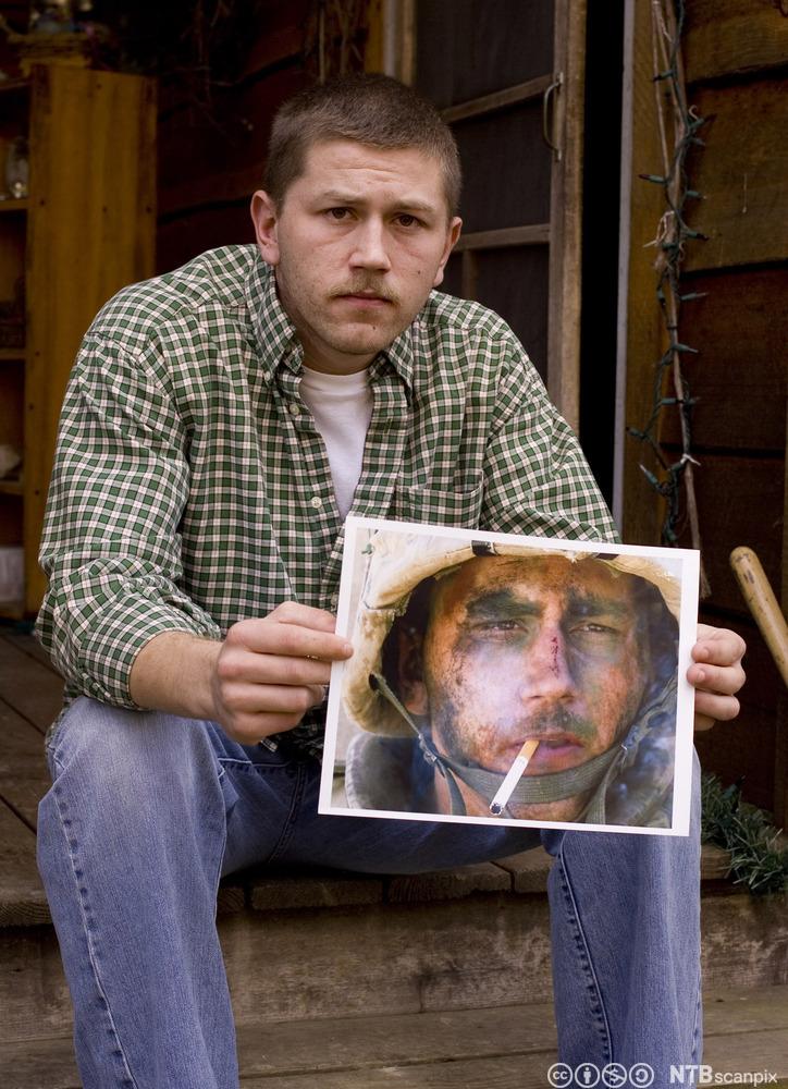 Den tidligere soldaten Blake Miller med et fotografi av seg selv fra dokumentaren The Marlboro Marine. Fotografi.