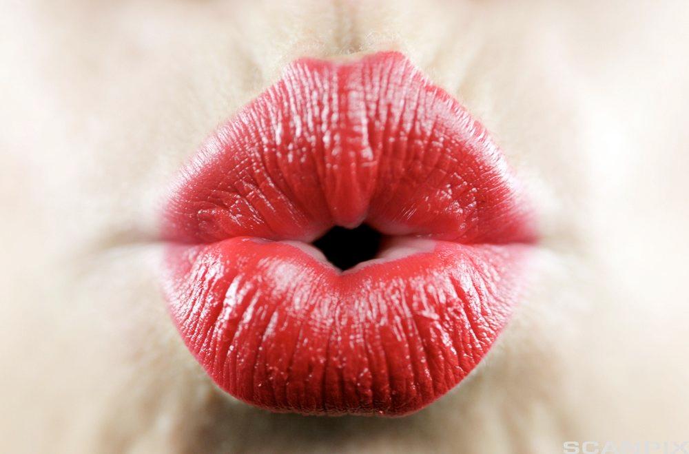 Nærbilde av munn med rød leppestift. Foto.