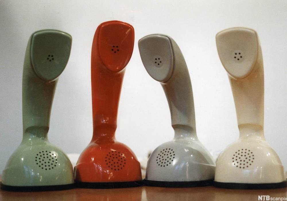Fire telefoner i ulike farger står utstilt ved siden av hverandre. Foto.