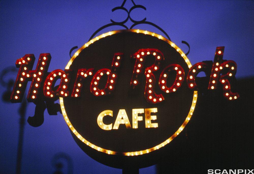 A Hard Rock Cafe sign in lights, at night. 