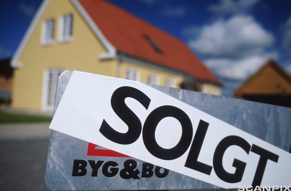 Solgt-skilt foran nytt hus. Foto.