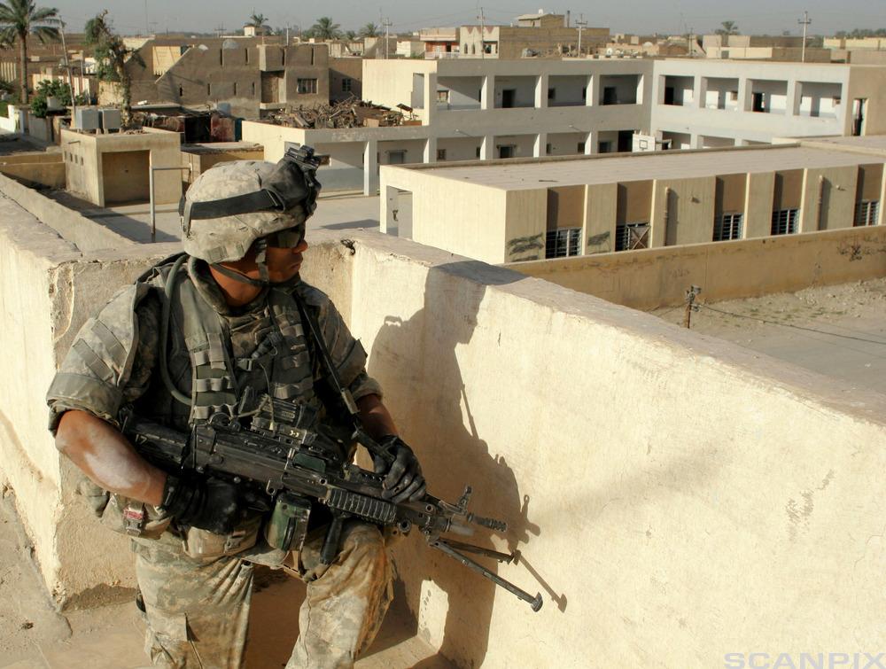A US soldier looks from a roof top during a mission