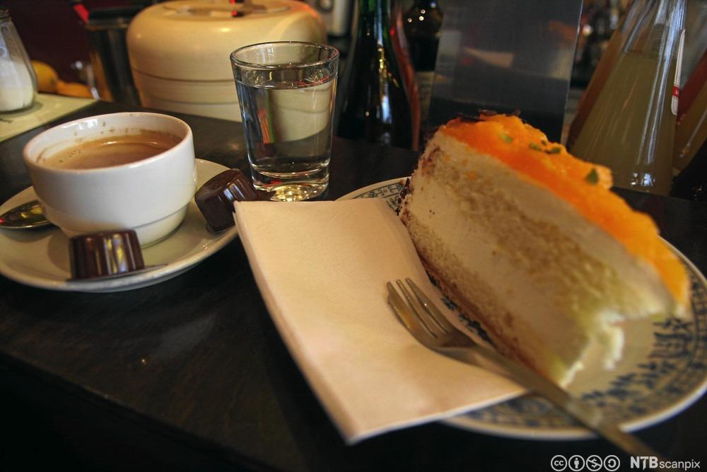 Kakestykke og kaffe på et kafébord. Foto